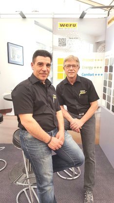 Zwei Mitarbeiter am Weru-Messestand präsentieren Fensterlösungen und Energieeffizienz.